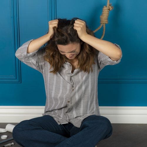 Depressed young girl crying and trying to hang herself. High quality photo